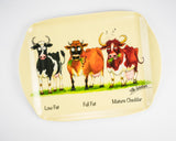 The Dairy Cattle themed melamine serving tray by Alex Underdown for Countryside Greetings features cartoon cows—Low Fat, Full Fat, and Mature Cheddar—each matching their label on a light background. British-made.