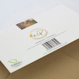 Close-up of the back of an A5 Gardening Greeting Card by Countryside Greetings, featuring elegant Verbena flowers, barcode, logos, website, and text: “Photograph by Charles Sainsbury-Plaice.” The card rests on a brown surface.