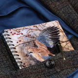 The Countryside Greetings Bird themed A6 lined notebook: Autumn Jay by Dick Twinney features a bird and red berries on the cover and comes with a gold and black pen—perfect for your next traditional writing notebook.